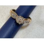 A 9ct yellow gold diamond ring with central round brilliant cut stone flanked by four further