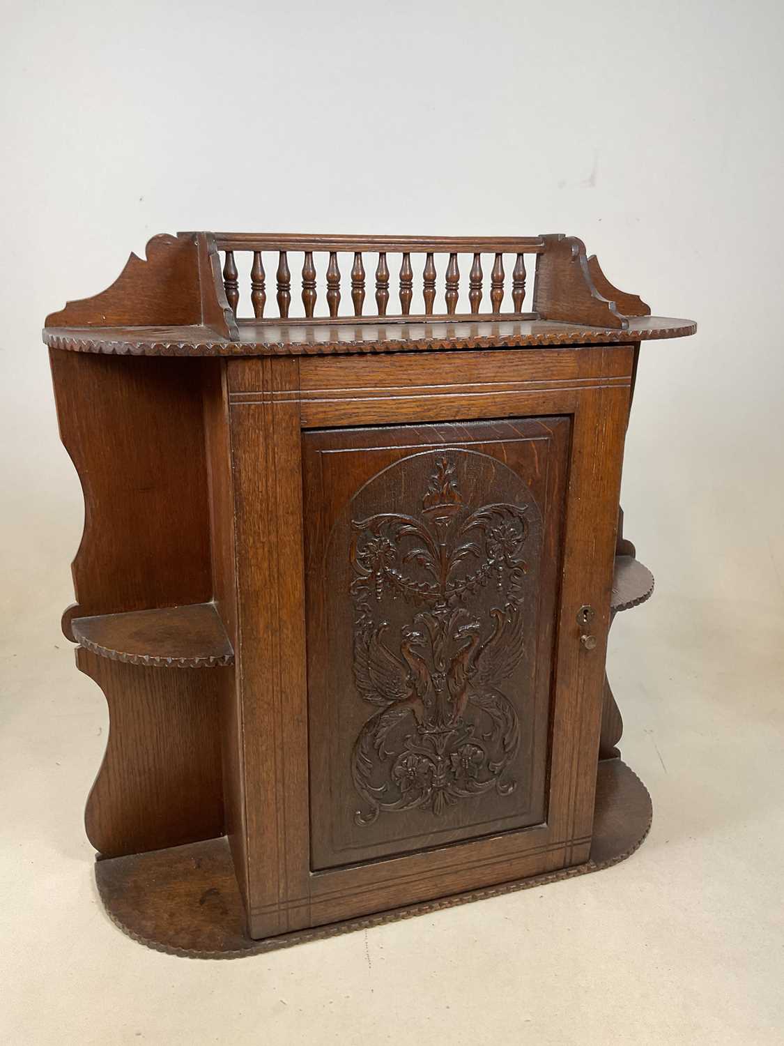 A circa 1900 oak hanging cabinet with spindle gallery above intricately carved hinged door enclosing - Image 2 of 8