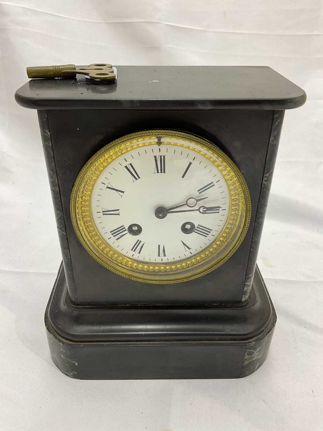 A late 19th century French black slate mantel clock with Roman numerals to the white enamel dial,