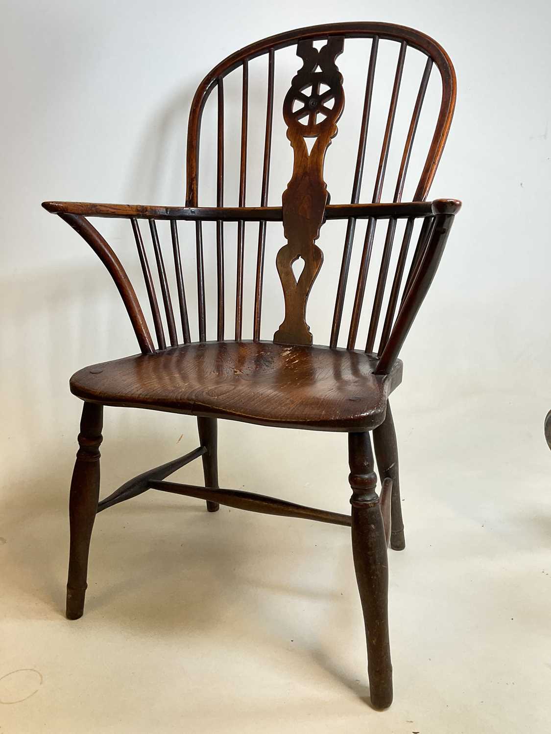 An early to mid-19th century ash and elm hoop back Windsor elbow chair with saddle seat and straight