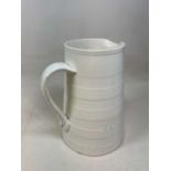 A large late 19th century cream glazed milk jug with moulded front handle and rear loop handle,