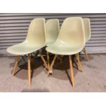 A set of four mid-century moulded chairs in the style of Charles Eames.