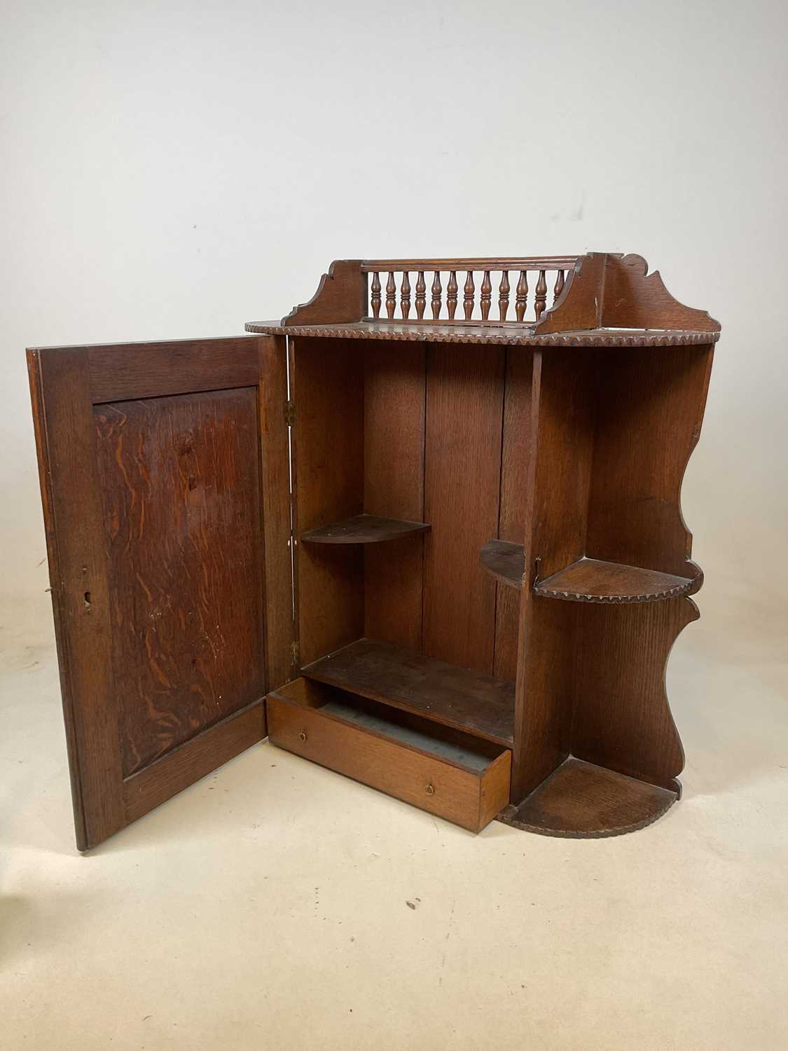 A circa 1900 oak hanging cabinet with spindle gallery above intricately carved hinged door enclosing - Image 5 of 8