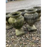 A pair of reconstituted urns and three circular planters (5).