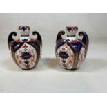 DERBY; a pair of late 19th century Imari decorated twin handled vases, both with painted printed and