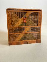 An early 20th century Japanese straw work decorated table top cabinet, width 21cm.Condition