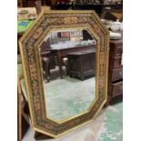 An unusual and decorative octagonal wall mirror, with stylised floral painted border and central