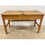 A vintage child's double sectioned desk with twin sliding brass inkwell reservoirs, width 112cm.