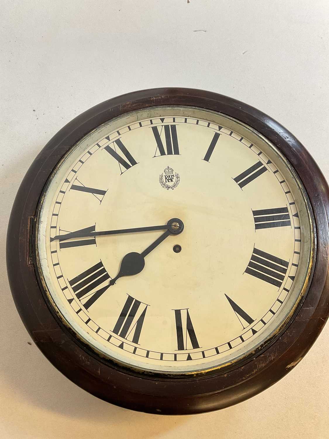 An early 20th century stained mahogany wall clock, the painted dial set with Roman numerals and