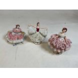Three Dresden porcelain figures with lace detail to the dresses.