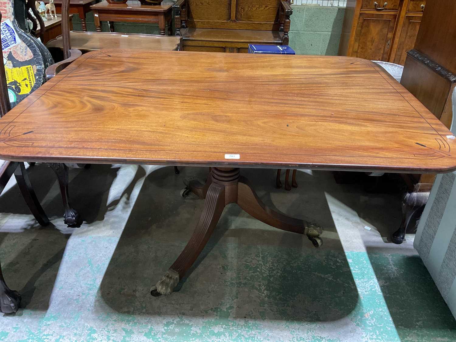 A George IV mahogany breakfast table, the rounded rectangular tilt-top raised above a ring turned