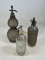 A double gourd soda syphon with mesh cage and two further soda syphons (3).