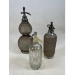 A double gourd soda syphon with mesh cage and two further soda syphons (3).