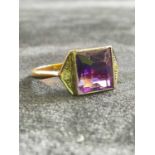 An Art Deco yellow metal dress ring with purple tinted central stone, size I, approx. 3.27g.