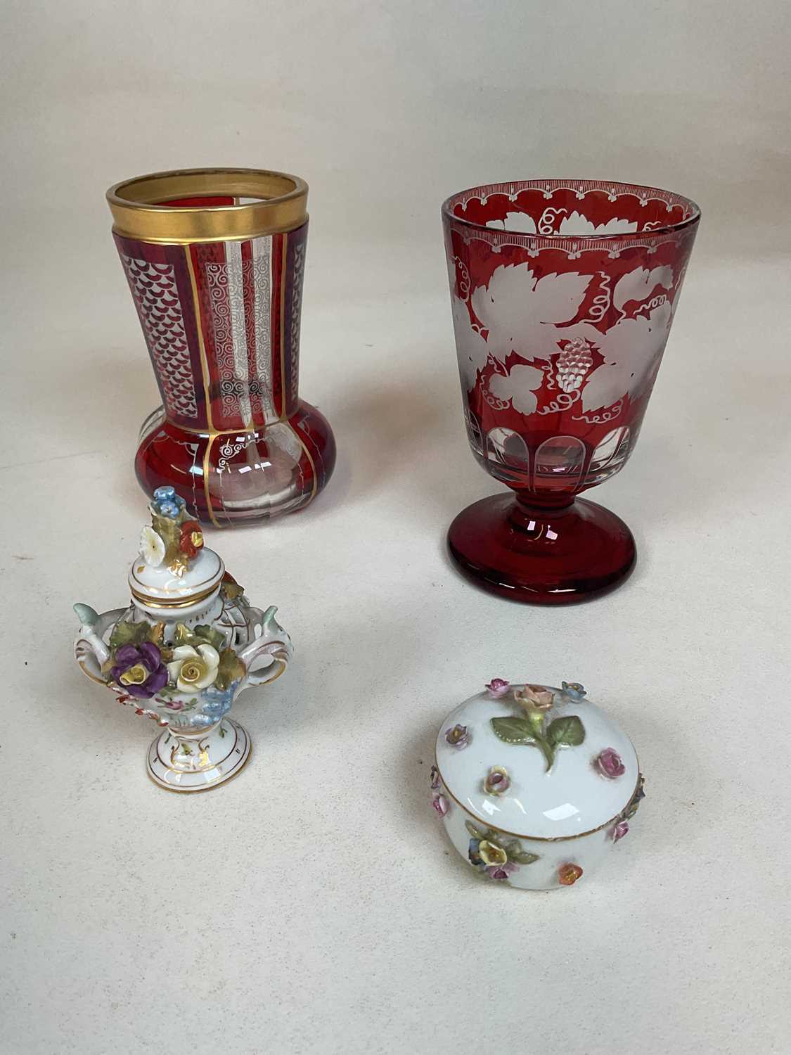 Two 19th century Bohemian ruby flash beakers, one with gilt decoration, the other with grape and