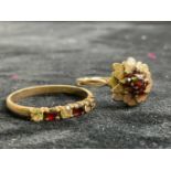 A 9ct yellow gold garnet set flower head ring, size R, and a further 9ct yellow gold dress ring,