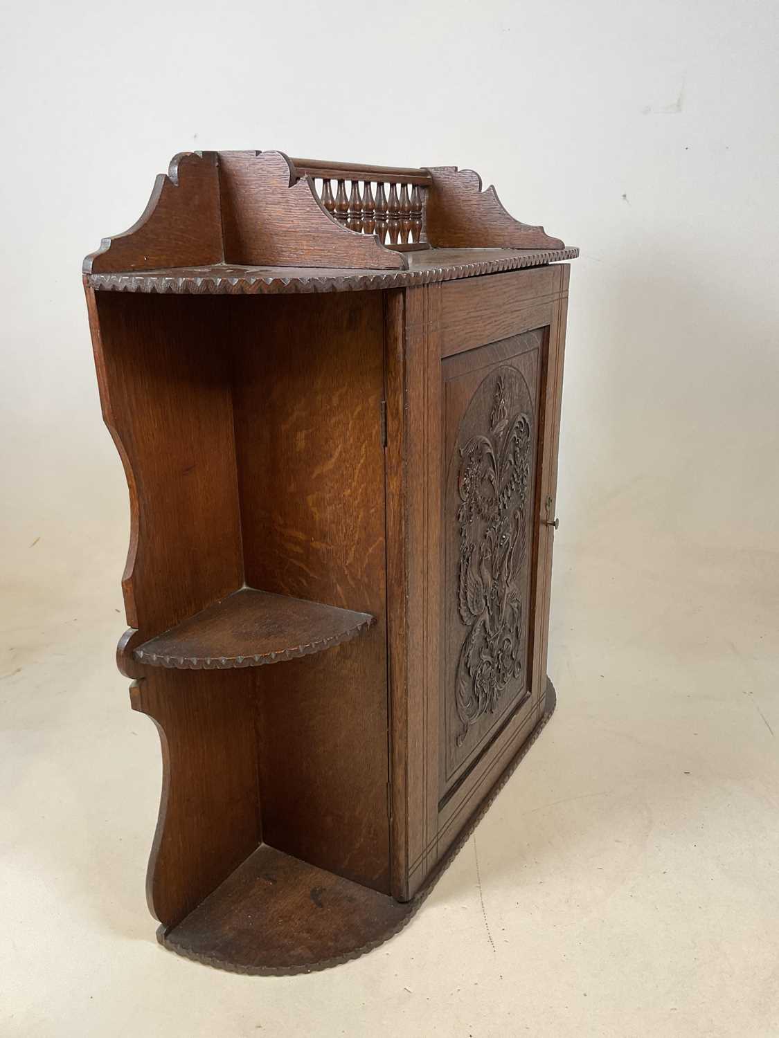 A circa 1900 oak hanging cabinet with spindle gallery above intricately carved hinged door enclosing - Image 8 of 8