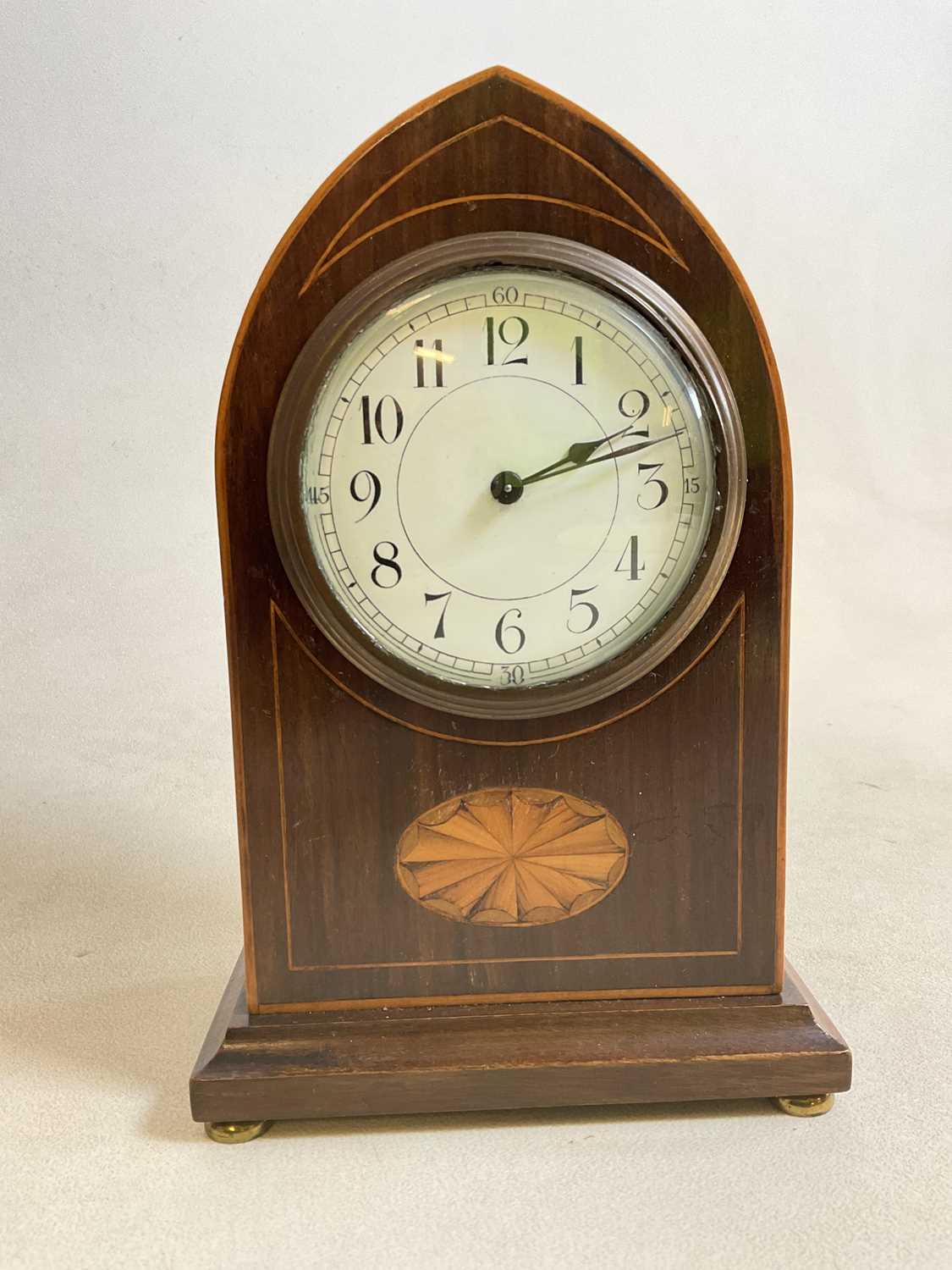 An Edwardian mahogany and inlaid lancet topped mantel timepiece with Arabic numerals to the white