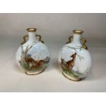 A pair of late 19th century white glazed moon flasks with gilt heightened pierced handles and each