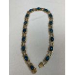 An 18ct yellow gold and polished blue agate set necklace formed of sixteen oval plaques, length 40.