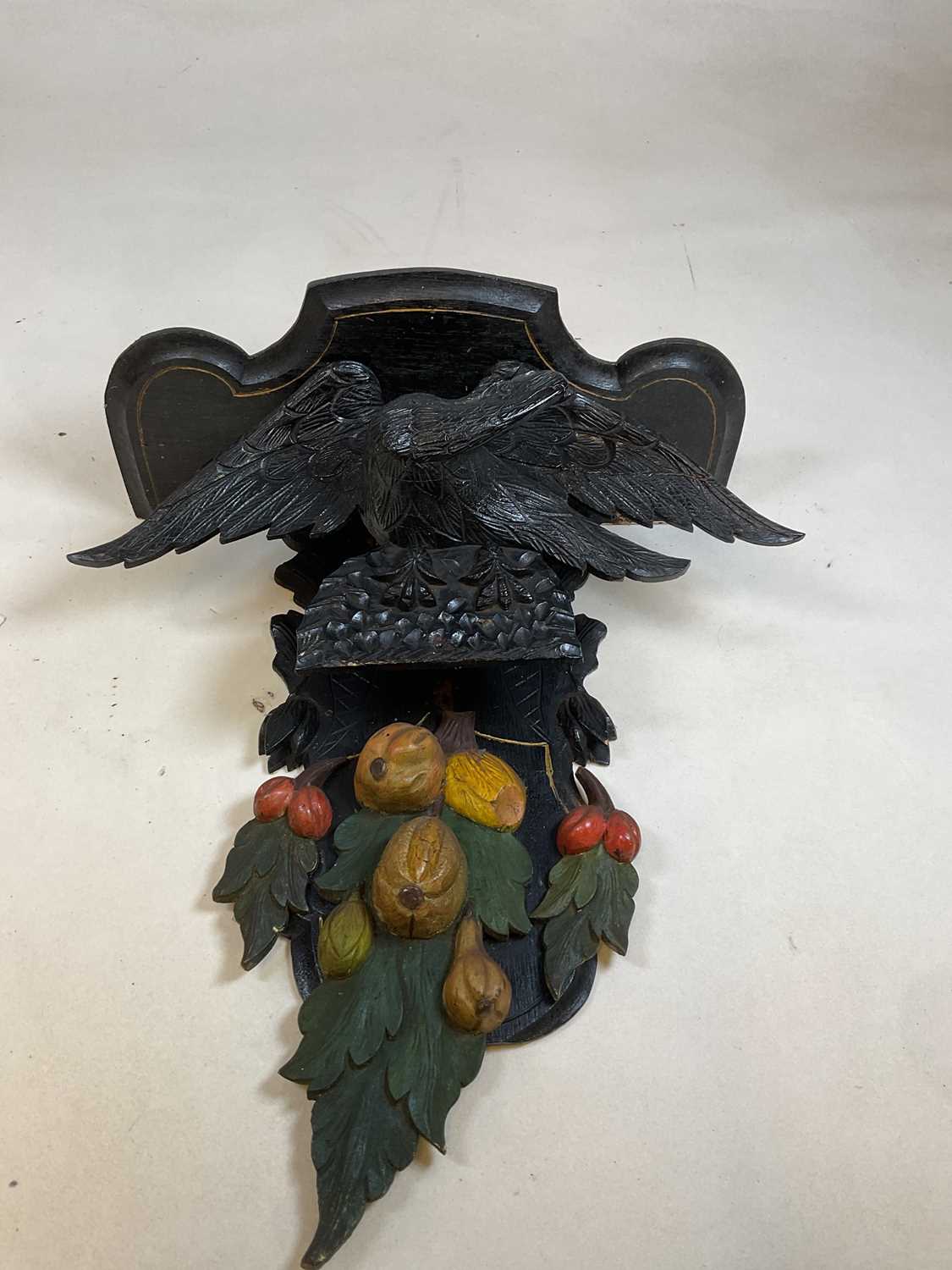 A painted and carved wall bracket set with an eagle above fruit 75cm h x 54cm W