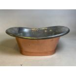 A copper and silvered metal sink with central aperture for plug, width 63cm.