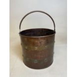 A late 19th century copper and stud decorated brass bound swing handled log bin, diameter 30cm.