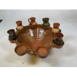 A treacle glazed stoneware punch bowl set with eight dished sections to the rim, with six jugs,
