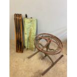 A vintage canvas and wooden framed folding bed, and an iron sprinkler