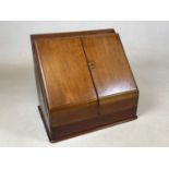 A c.1900 mahogany stationery cabinet with hinged upper section enclosing a perpetual calendar,