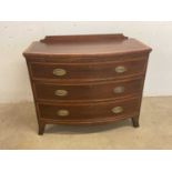 A mahogany satinwood crossbanded bowfronted chest of three graduated drawers raised on splayed