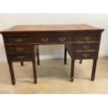 An Edwardian mahogany and fret detailed desk raised on turned cluster column supports, width 122cm.