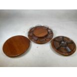 DIGSMED OF DENMARK; three teak lazy Susan's two with smoked glass inserts, largest diameter 40cm.