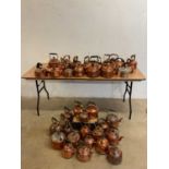 A large collection of approximately forty assorted electric copper kettles