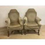 A pair of early 20th century Continental upholstered high back armchairs raised on carved oak