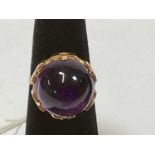A 14 ct yellow gold and large cabochon amethyst set dress ring, size I, approx. 5.8g.