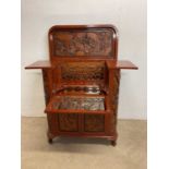 A mid to late 20th century Chinese carved bar with hinged lid enclosing a mirrored interior, twin