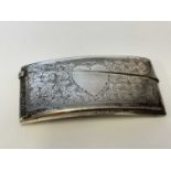 A George V hallmarked silver card case of curved form with leaf engraved detail and vacant heart