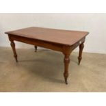 A pitch pine dining table with rounded rectangular one piece top above frieze drawer raised on