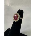An 18ct yellow gold ruby and diamond oval cluster ring, the oval ruby measuring approx. 10.5mm x
