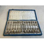 A cased set of twelve Continental white metal teaspoons with shell moulded bowls and matching
