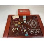 A quantity of costume jewellery including a bangle, brooches, cased studs, etc, all contained within
