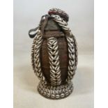 An antique Ethiopian woven fibre milk container, the leather decorated with seashells, height 35cm.