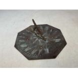 A 19th century octagonal copper sun dial with pierced gnomon and the plate inscribed 'Night Cometh',