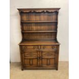 A reproduction oak dresser with boarded plate rack, width 123cm.