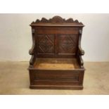 A c.1900 carved oak hall bench with mask detail to the arms and hinged box seat, width 96cm.