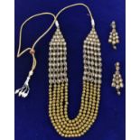 An Indian yellow metal 'polki' necklace with matching pair of earrings, length of earrings approx
