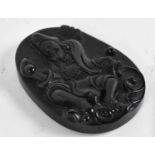 A black stone cameo carved with smiling Buddha, 6 x 4cm.