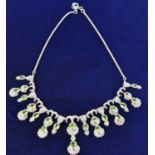 An Indian white metal diamond and green peridot necklace formed of graduated drops, length 39cm,