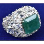 A very large Indian white sapphire and emerald dress ring, set in white metal, central stone